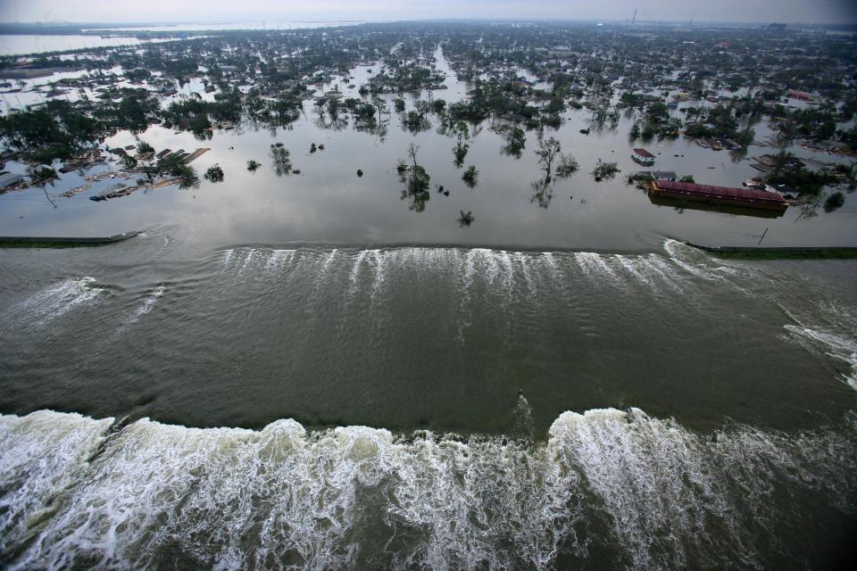 Floodwaters from Hurricane Katrina pour through a levee along Inner Harbor Navigaional Canal near downtown New Orleans, La., Tuesday, Aug. 30, 2005, a day after Katrina passed through the city. (AP Photo/Vincent Laforet, Pool)