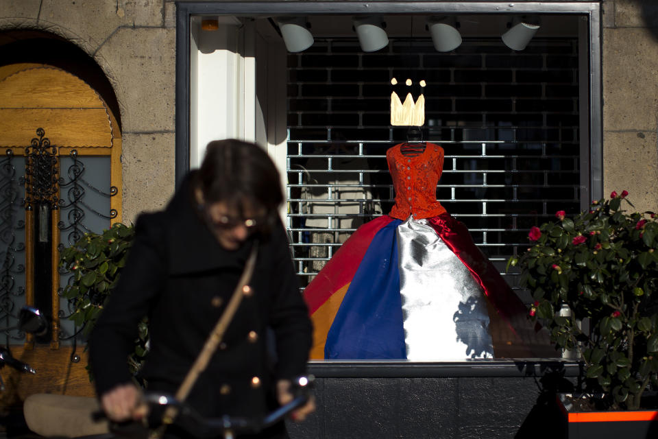 A crown and a dress with The Netherlands flag colors decorates a shop window in Amsterdam, Netherlands Sunday, April 28, 2013. Queen Beatrix announced she will relinquish the crown on April 30, 2013, after 33-years of reign, leaving the monarchy to her son Crown Prince Willem Alexander. (AP Photo/Daniel Ochoa de Olza)
