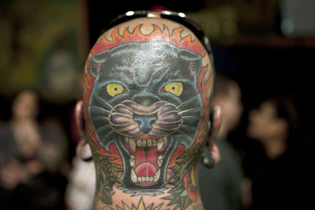 A tattooed panther is seen on the back of the head of a man during the 15th Annual Tattooing Convention in Manhattan in New York, May 19, 2012. AFP PHOTO / MLADEN ANTONOV