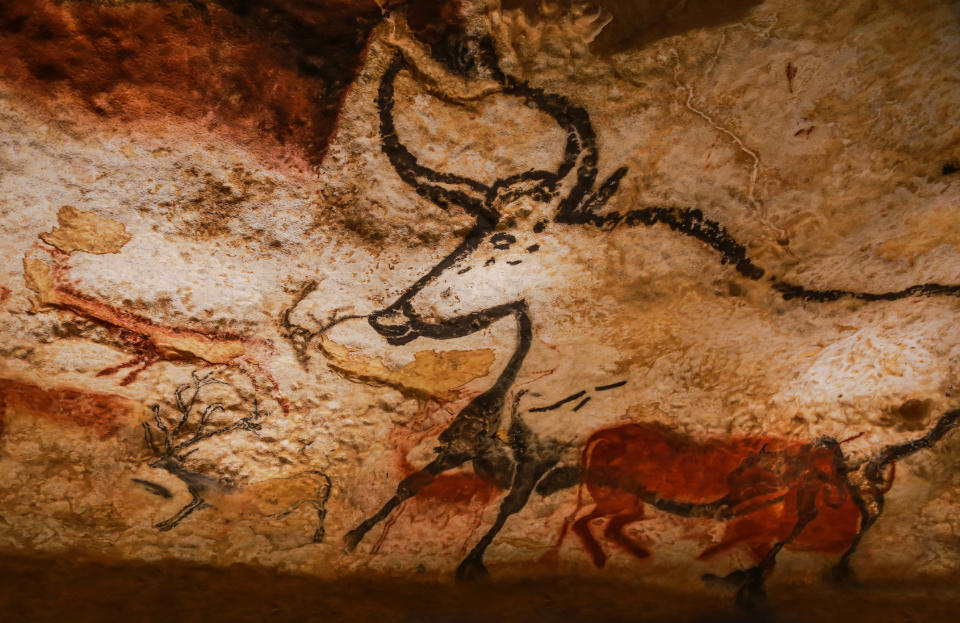 Ancient cave painting showing large animals, including a prominent bull with horns, located in a historical site. Image taken at a travel destination