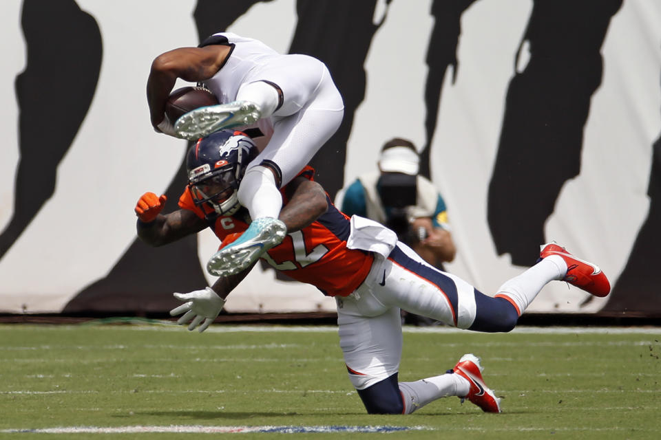 Jacksonville Jaguars wide receiver Marvin Jones Jr., left, is upended by Denver Broncos safety Kareem Jackson after a reception during the first half of an NFL football game, Sunday, Sept. 19, 2021, in Jacksonville, Fla. (AP Photo/Stephen B. Morton)