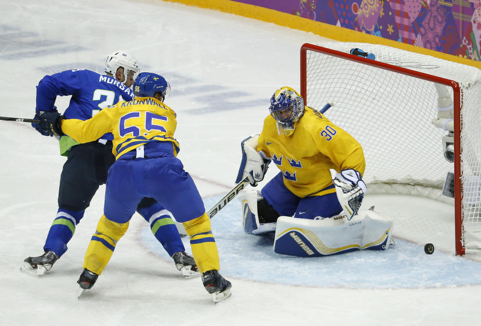 Sweden goaltender Henrik Lundqvist blocks a shot by Slovenia forward Jan Mursak as Sweden defenseman Niklas Kronwall helps defend in the second period of a men's ice hockey game at the 2014 Winter Olympics, Wednesday, Feb. 19, 2014, in Sochi, Russia. Sweden won 5-0. (AP Photo/Mark Humphrey)