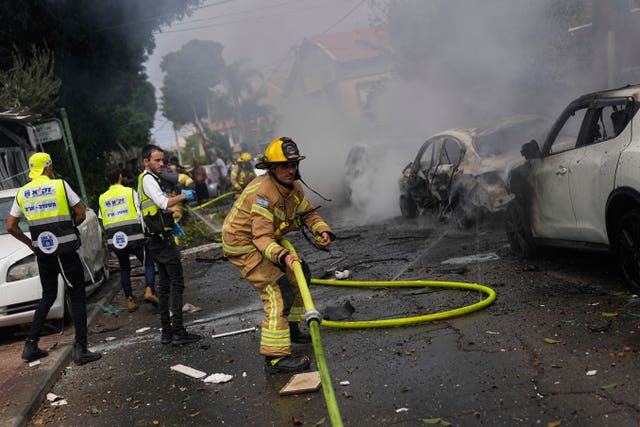 Israeli firefighters extinguish fire at a site struck by a rocket fired from the Gaza Strip in Ashkelon, southern Israel, on Monday