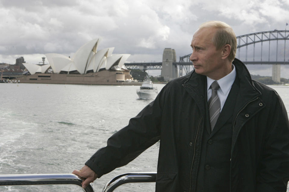 Photo of Russian President Vladimir Putin standing onboard a yacht with the Sydney Harbopur Bridge and Opera House in the background. (Source:Getty)