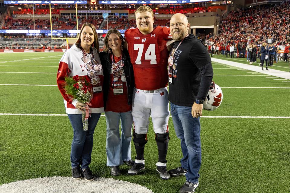 Wisconsin senior Michael Furtney (74) is recognized prior to a game on Nov. 18, 2023, in Madison, Wis. Joining him on the field were his parents Matthew and Ellen and his wife Clare.