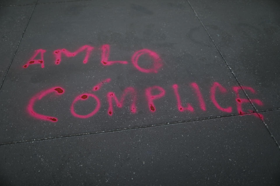 FILE - In this Feb. 15, 2021 file photo, the Spanish graffiti message "AMLO is complicit" is written on the ground outside the National Palace, as a women's collective protests against support by the ruling Morena party, led by Mexican President Andres Manual Lopez Obrador, known familiarly as AMLO, for gubernatorial candidate Felix Salgado Macedonio in Mexico City. Citing multiple accusations of rape and sexual assault against Salgado, the "Not one aggressor in power" feminist collective is protesting Salgado's candidature and the ruling Morena party for backing him. (AP Photo/Rebecca Blackwell, File)