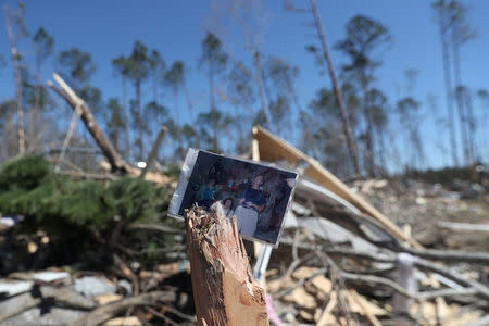 A family photograph sits placed on the remains of a tree outside a destroyed home after two deadly back-to-back tornadoes, in Beauregard, Alabama, U.S., March 5, 2019. REUTERS/Shannon Stapleton