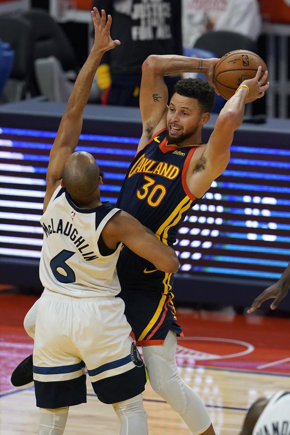 Golden State Warriors guard Stephen Curry (30) looks to pass the ball while defended by Minnesota Timberwolves guard Jordan McLaughlin (6) during the first half of an NBA basketball game in San Francisco, Wednesday, Jan. 27, 2021. (AP Photo/Jeff Chiu)