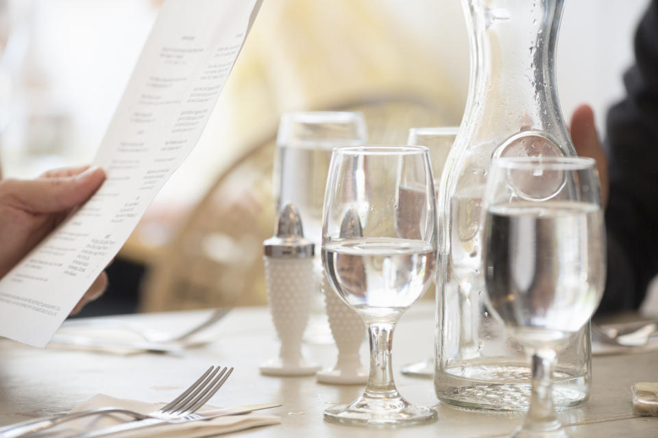 A pitcher of water and glasses on a table.