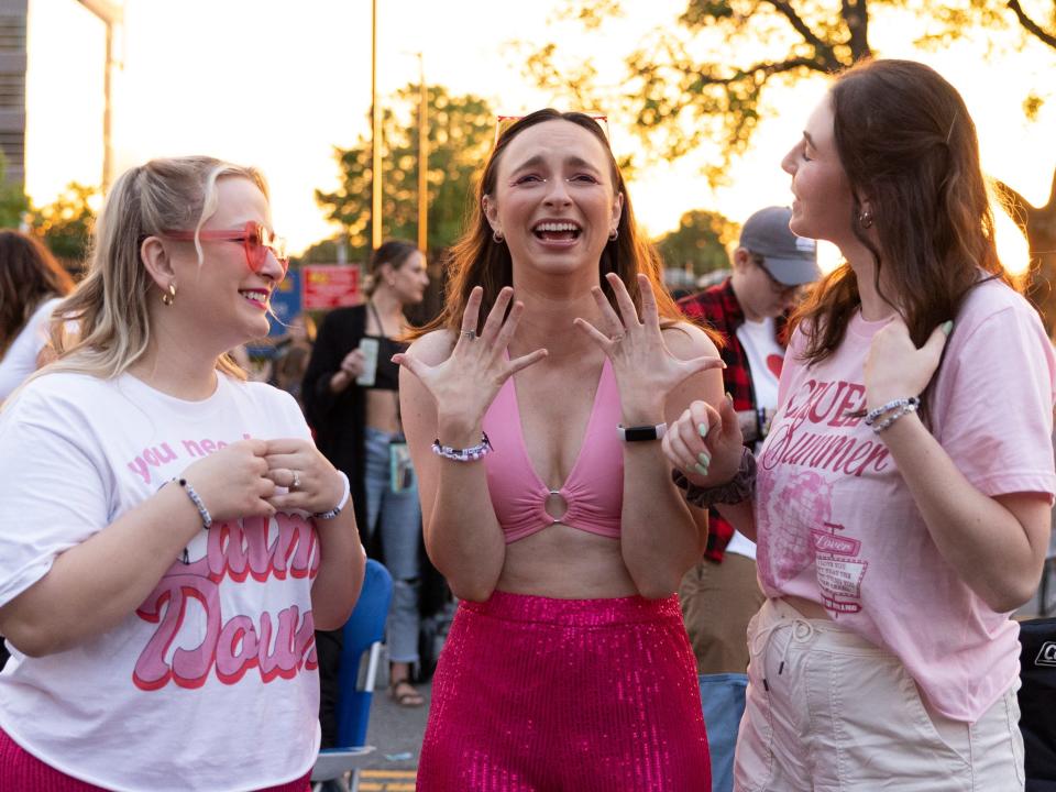 Megan Whittle, Christy White, and Emma Pizzi react to the beginning of Taylor Swift's set, which they are listening to from the parking lot outside of Lincoln Financial Field, in Philadelphia, Pennsylvania on May 13, 2023.