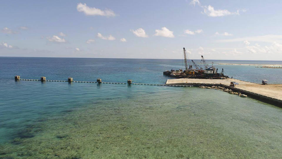 In this handout photo provided by the Department of National Defense PAS, ships carrying construction materials are docked at the newly built beach ramp at the Philippine-claimed island of Pag-asa, also known as Thitu, in the disputed South China Sea, Tuesday June 9, 2020. The Philippine defense chief and top military officials flew to a disputed island in the South China Sea Tuesday to inaugurate a beach ramp built to allow the "full-blast" development of the far-flung territory but would likely infuriate China. (Department of National Defense PAS via AP)