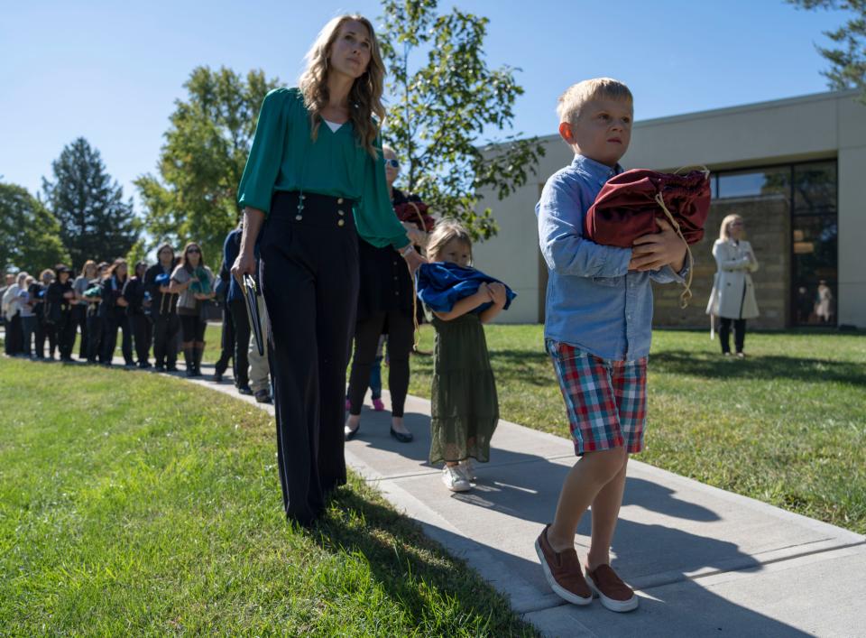 Molly Grollimund, left, walks with her kids Jovie, 5, and Sawyer, 7, while carrying Indianapolis’ unclaimed cremated remains to be buried Monday, Sept. 26, 2022, at Oaklawn Memorial Gardens in Fishers.