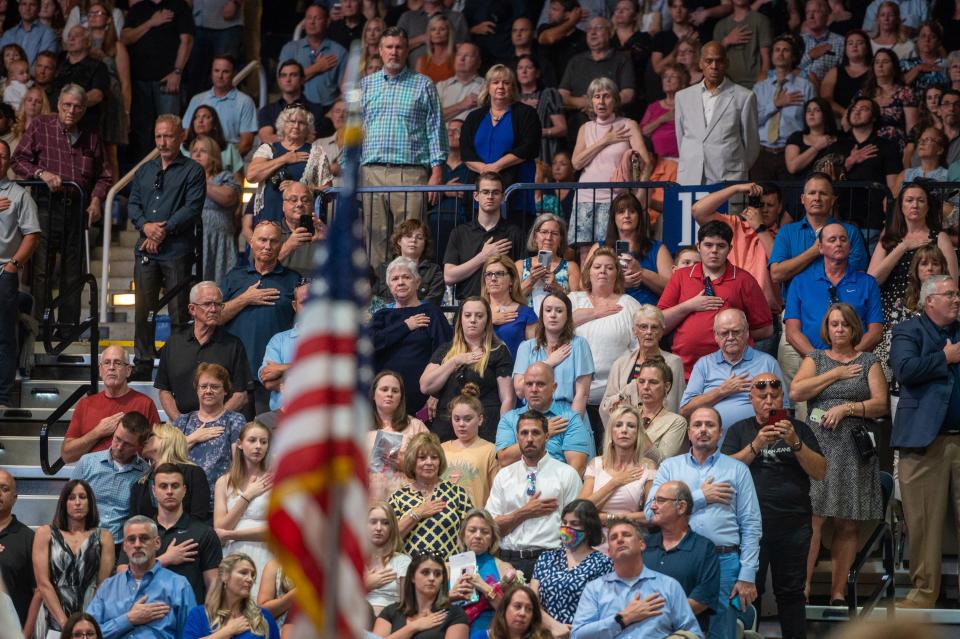 Family members and friends of Bartram Trail High School's class of 2022 say the Pledge of Allegiance at the start of the school's commencement ceremony, held on the University of North Florida campus in Jacksonville on Tuesday, May 31, 2022.