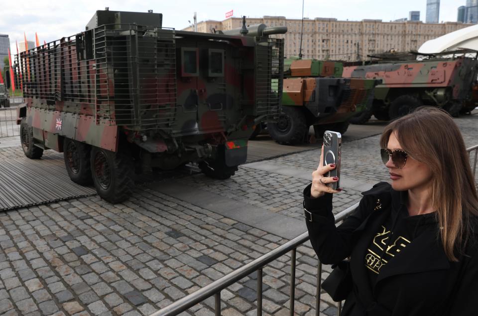 A woman takes a photo next to a UK-made Mastiff.