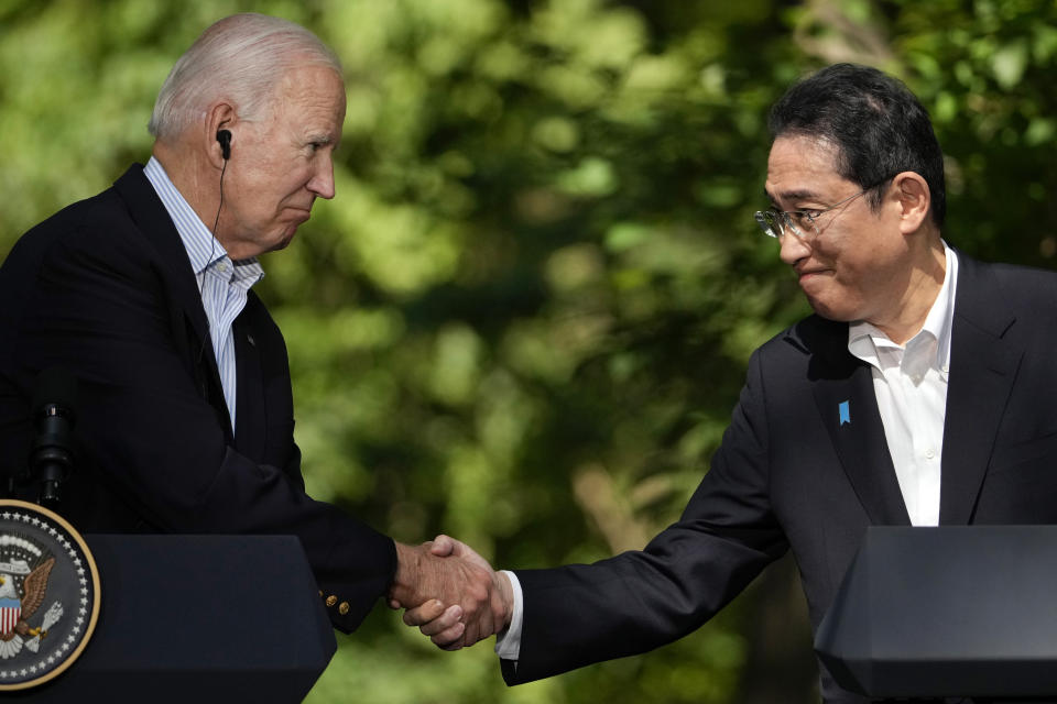 FILE - U.S. President Joe Biden, left, shakes hands with Japan's Prime Minister Fumio Kishida during a joint news conference with South Korean President Yoon Suk Yeol, not visible, on Aug. 18, 2023, at Camp David, the presidential retreat, near Thurmont, Md. Prime Minister Kishida is making an official visit to the United States this week. He will hold a summit with President Biden that's meant to achieve a major upgrading of their defense alliance.(AP Photo/Andrew Harnik, File)