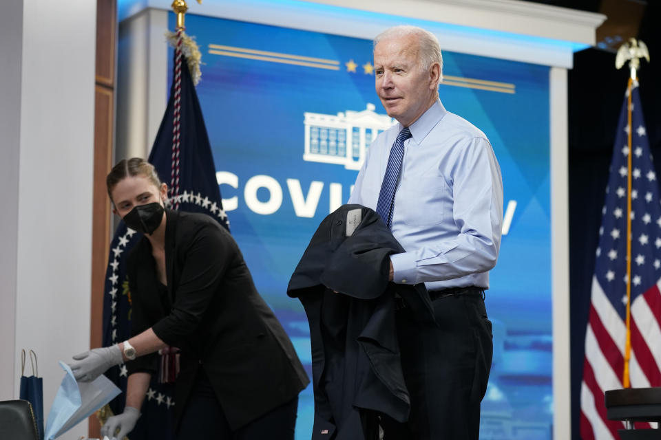 President Joe Biden removes his jacket before receiving his second COVID-19 booster shot in the South Court Auditorium on the White House campus, Wednesday, March 30, 2022, in Washington. (AP Photo/Patrick Semansky)