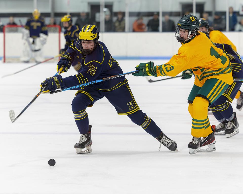 Hartland's Jake Pietila tries to keep the puck away from Howell's Landen Switala during the Eagles' 5-0 victory Wednesday, Jan. 11, 2023 at 140 Ice Den.