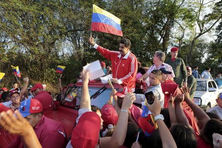 Venezuela's President Nicolas Maduro (C) waves a Venezuelan national flag during a campaign rally at Valles del Tuy in Miranda state, Venezuela, in this handout picture provided by Miraflores Palace on November 26, 2015. REUTERS/Miraflores Palace/Handout via Reuters