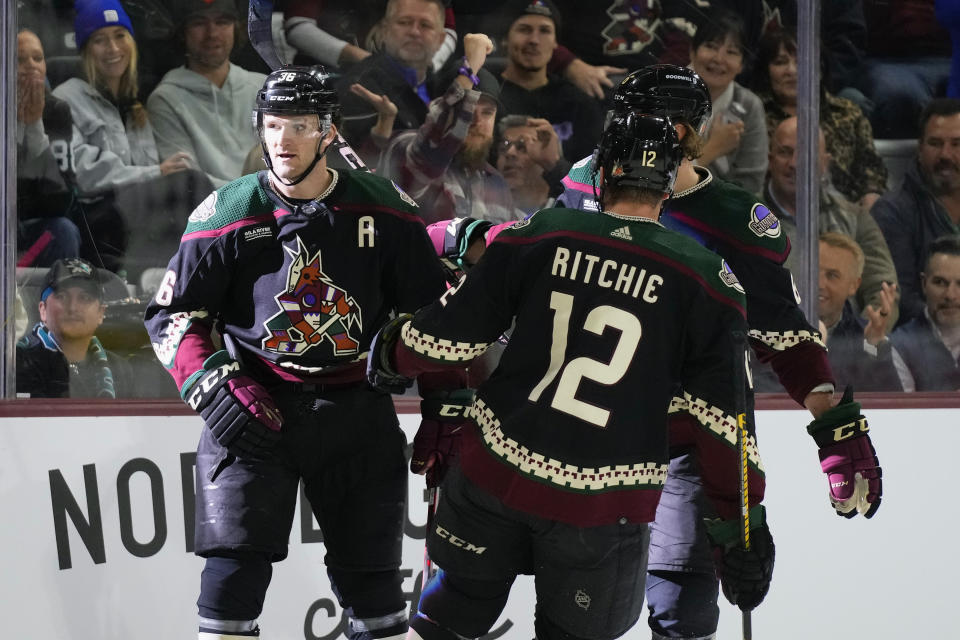 Arizona Coyotes right wing Christian Fischer, left, celebrates his goal against the San Jose Sharks with Coyotes left wing Nick Ritchie (12) and Coyotes defenseman Jakob Chychrun, back right, during the first period of an NHL hockey game in Tempe, Ariz., Tuesday, Jan. 10, 2023. (AP Photo/Ross D. Franklin)