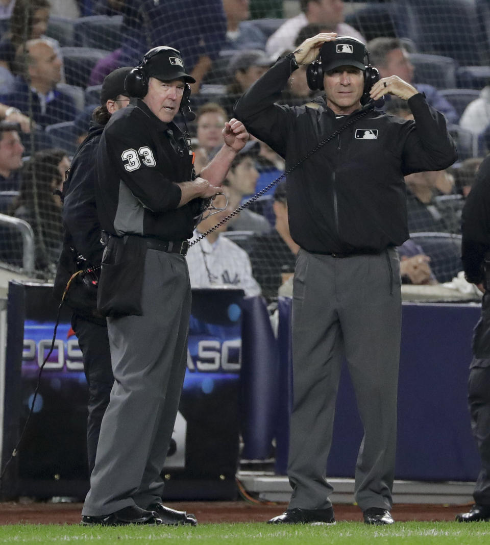 umpire Mike Winters (33) and first base umpire Angel Hernandez wait for the call on a review of a play at first base during the fourth inning of Game 3 of baseball's American League Division Series between the New York Yankees and the Boston Red Sox, Monday, Oct. 8, 2018, in New York. (AP Photo/Frank Franklin II)