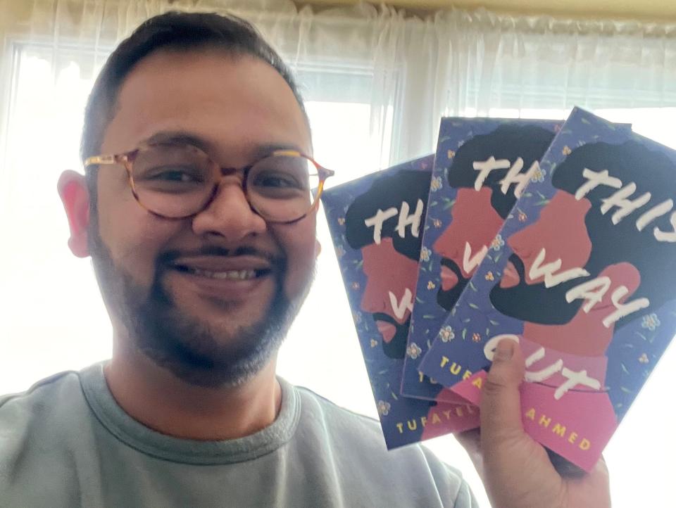 Image of Tufayel Ahmed holding copies of his book, "This Way Out."