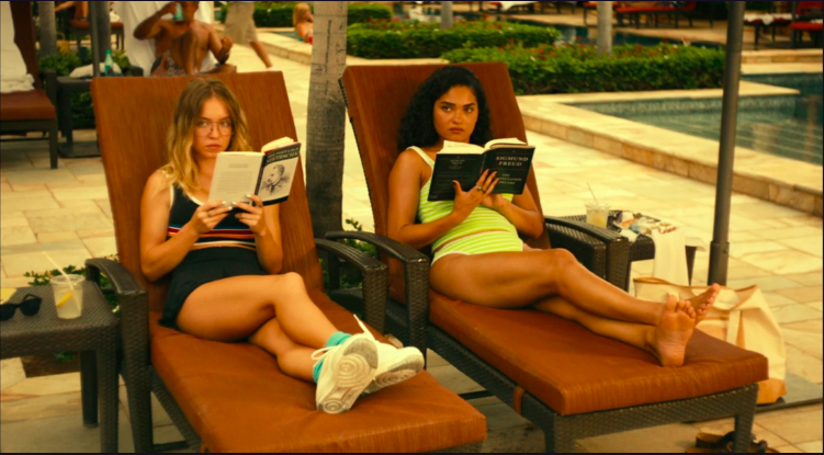 two young women sit poolside in "white lotus"