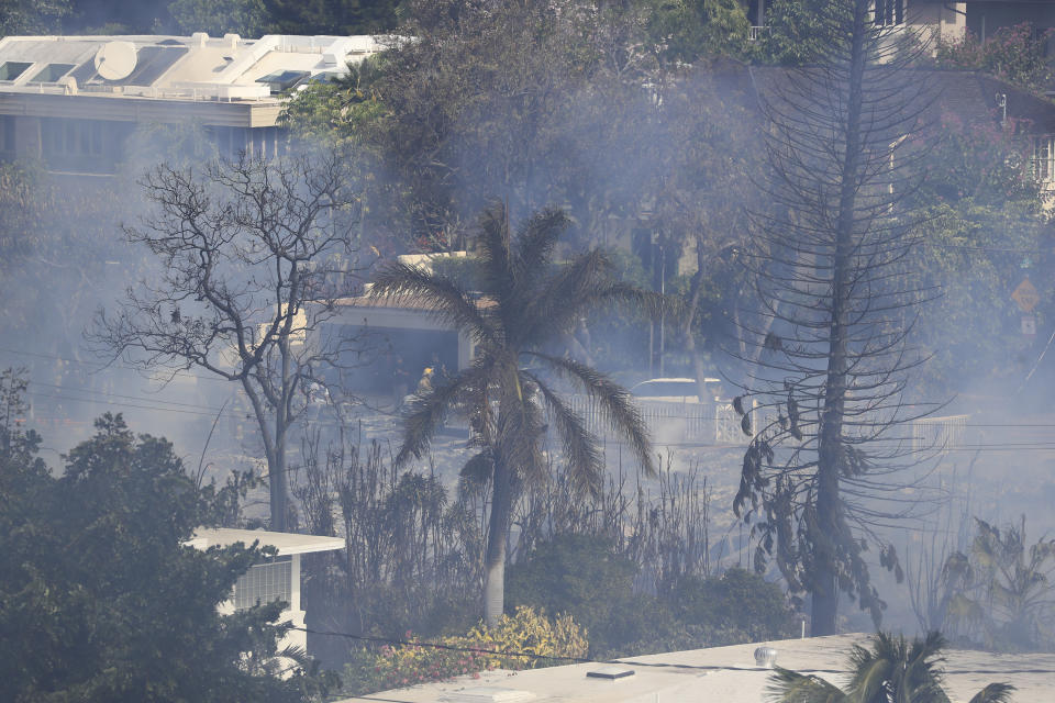 Several homes burn in near Diamond Head, Sunday, Jan. 19, 2020, in Honolulu, following a shooting in which two police officers were shot. (AP Photo/Marco Garcia)