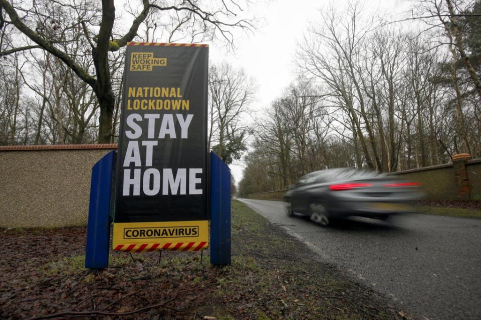A car drives past a coronavirus information sign in Brookwood, Surrey, during the second wave of Covid-19 in January 2021 (Steve Parsons/PA) (PA Archive)