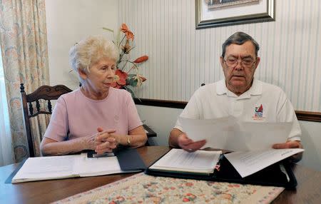 Retired engineer Bill Jenkins and his wife Carol look over documents concerning their investment in Reef's Income & Development Fund II at their home in Orlando, Florida, October 31, 2014. REUTERS/Steve Nesius