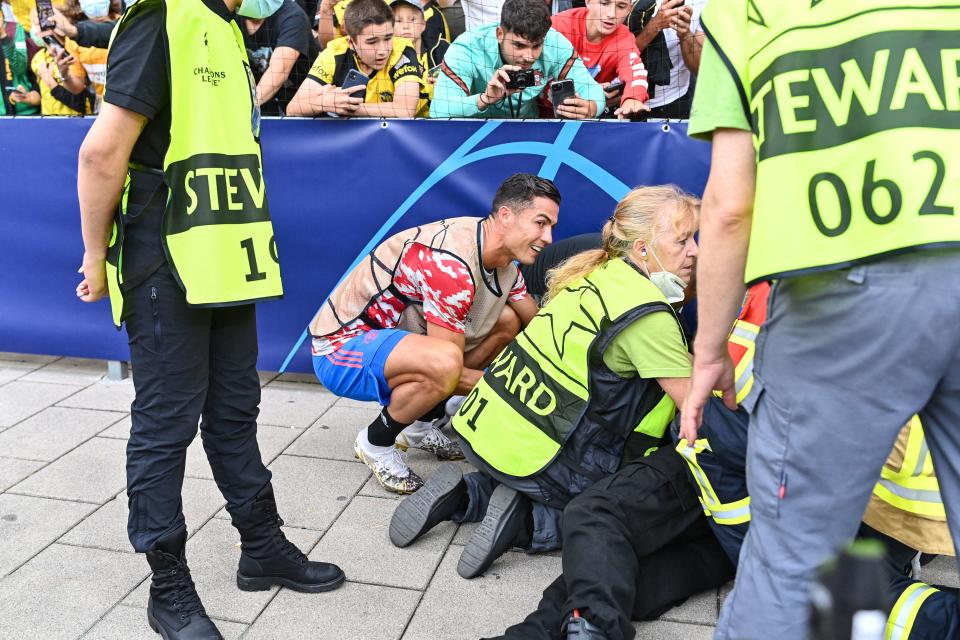 El delantero del Manchester United Cristiano Ronaldo ofrece excusas al guardia de seguridad que recibió un pelotazo durante el calentamiento previo al juego por la Champions League. (Fotos: Getty Images)