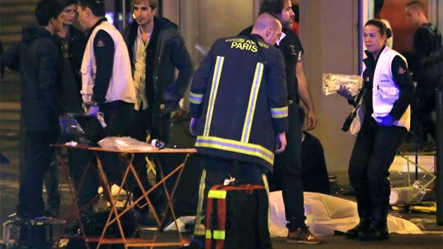 Rescue workers at the scene as victims lay on the pavement outside a Paris restaurant. Photo: AP/Thibault Camus