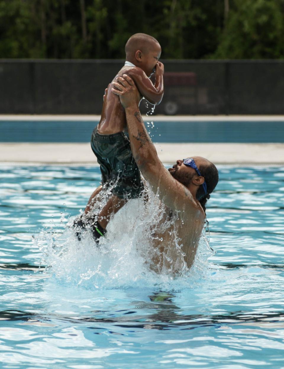 Counsel Gaynor of Detroit tosses his son Counsel Gaynor Jr 4 while on Wednesday July 9, 2014 after the grand re-opening of the two olympic-size swimming pools and bath house at the historic Brennan Pools located in Rouge Park on Detroit's west side. Ryan Garza / Detroit Free Press