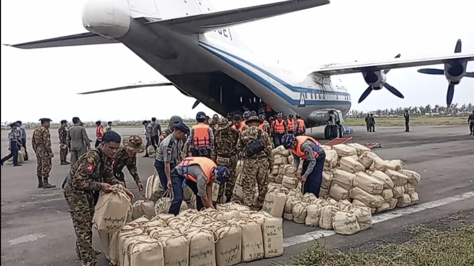 In this photo provided by Myanmar Military True News Information Team on Monday, May 15, 2023, soldiers and polices unload relief items for victims at airport after Cyclone Mocha in Sittwe township, Rakhine State, Myanmar. Rescuers on Monday evacuated about 1,000 people trapped by seawater 3.6 meters (12 feet) deep along western Myanmar's coast after the powerful cyclone injured hundreds and cut off communications. (Military True News Information Team via AP)