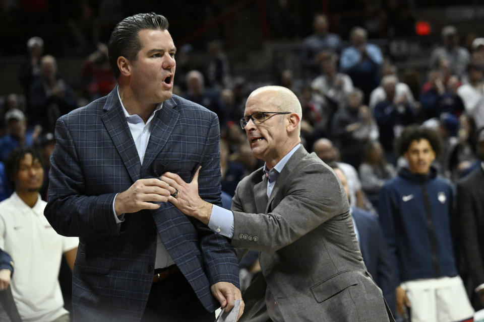UConn head coach Dan Hurley, right, holds back assistant head coach Tom Moore, left, in the second half of an NCAA college basketball game against New Hampshire, Monday, Nov. 27, 2023, in Storrs, Conn. (AP Photo/Jessica Hill)