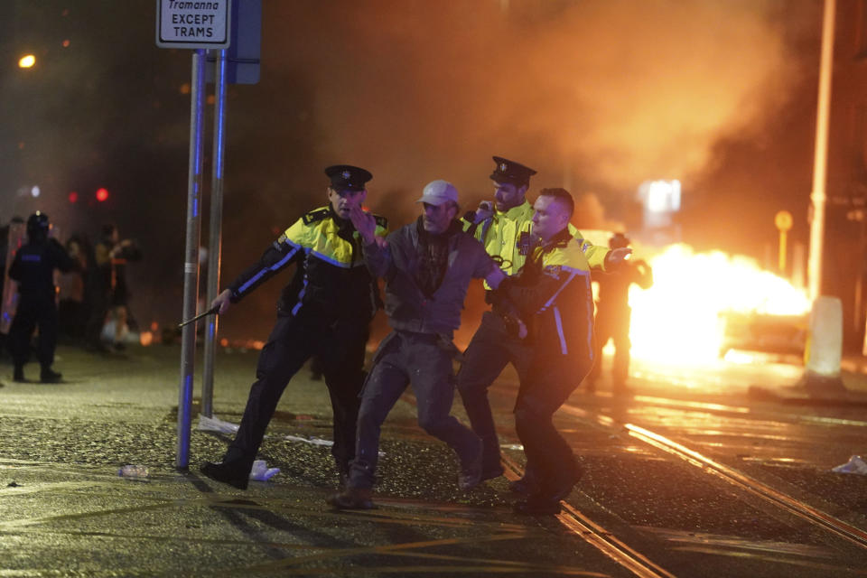 Agentes de policía irlandeses detienen a un hombre tras una manifestación violenta el jueves 23 de noviembre de 2023, en el centro de Dublín. (Brian Lawless/PA vía AP)