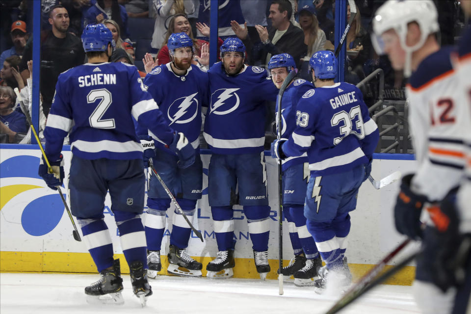 Tampa Bay Lightning's Pat Maroon, center, is congratulated by teammates, from left, Luke Schenn, Braydon Coburn, Mitchell Stephens and Cameron Gaunce after scoring against the Edmonton Oilers during the second period of an NHL hockey game Thursday, Feb. 13, 2020, in Tampa, Fla. (AP Photo/Mike Carlson)