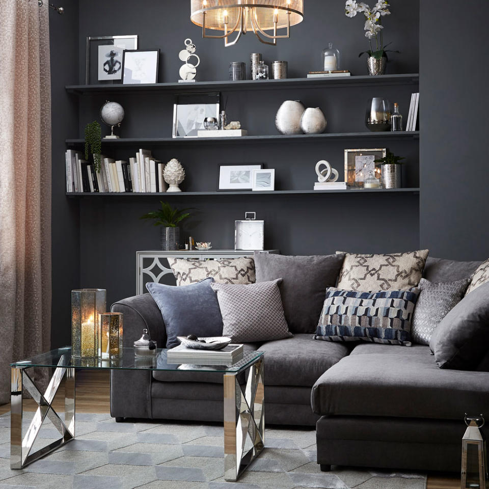 <p> Smart and sophisticated, charcoal grey brings depth to an elegant living room. Smart geometric designs on the cushions and rug along with polished chrome accents bring a timeless touch of boutique chic to the space. </p> <p> Create the illusion of expensive, built-in storage by painting shelving the same colour as the walls. For example, alcoves can become a smart feature wall that's easy to adjust. But sticking to a simple palette of black, white and silver reflects the pared back aesthetic of the room. </p>
