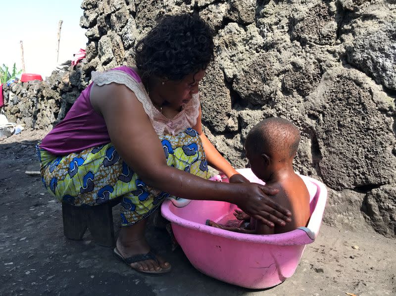 Ebola victim of Goma, Esperance Nyabintu bathes her son Ebenezer Fataki, at her compound within Bugamba locality in Goma