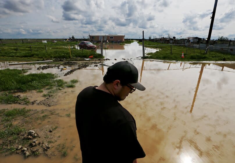 ALLENSWORTH, CALIF. - M,AR. 20, 2023. Juan Espinoza, 21, walks around the flooded property where he lives in Allensworth, a small hamlet in rural San Joaquin Valley. Portions of the town have been flooded during recent rains because of its low-lying location. Residents are bracing for forecasted rain that may further innundate the community. (Luis Sinco / Los Angeles Times)