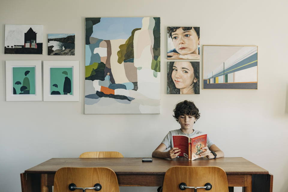 Ronan Golub lee un libro con su Apple Watch puesto, en casa en Nueva York, el 25 de agosto de 2022. (Jeenah Moon/The New York Times)
