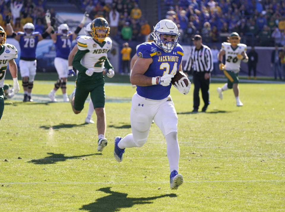 CORRECTS TO SOUTH DAKOTA STATE FULLBACK MICHAEL MORGAN NOT NORTH DAKOTA STATE FULLBACK LUKE WATERS - South Dakota State fullback Michael Morgan (34) runs for a touchdown in front of North Dakota safety Dawson Weber (2) during the first half of the FCS Championship NCAA college football game Sunday, Jan. 8, 2023, in Frisco, Texas. (AP Photo/LM Otero)