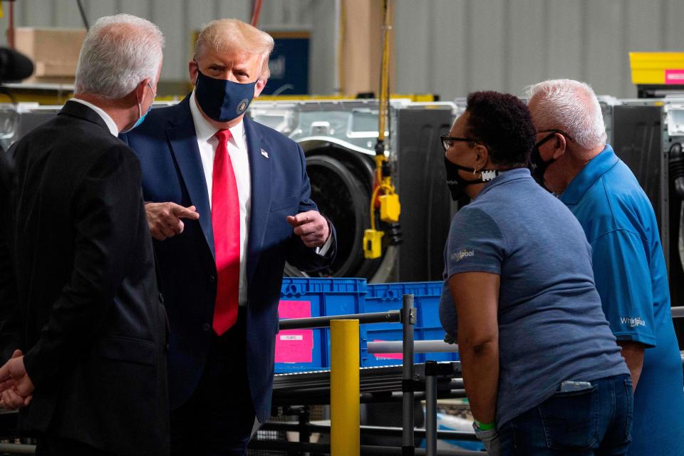 President Donald Trump wears a face mask as he speaks to employees on a tour of the Whirlpool manufacturing plant in Clyde, Ohio.