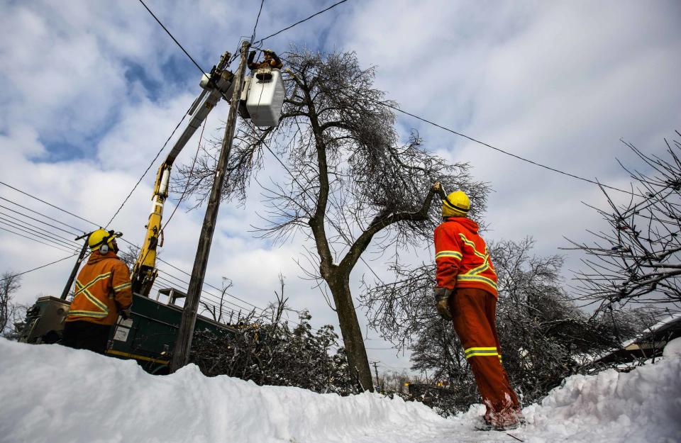 Toronto Hyrdro workers work to restore power following an ice storm in Toronto, December 27, 2013. Over 30,000 residents were left without power in Toronto Friday since the storm hit on December 22, local media reported. REUTERS/Mark Blinch (CANADA - Tags: ENVIRONMENT ENERGY)