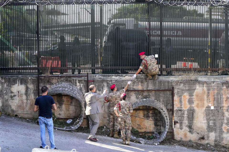 Lebanese Army investigators inspect bullet holes and collect forensic evidence next to the entrance of U.S. Embassy in Aukar, a northern suburb of Beirut, Lebanon, Thursday, Sept. 21, 2023. Lebanon's security agencies have launched an investigation into a late night shooting outside the U.S. embassy in Lebanon that caused no injuries, officials said Thursday. (AP Photo/Hassan Ammar)