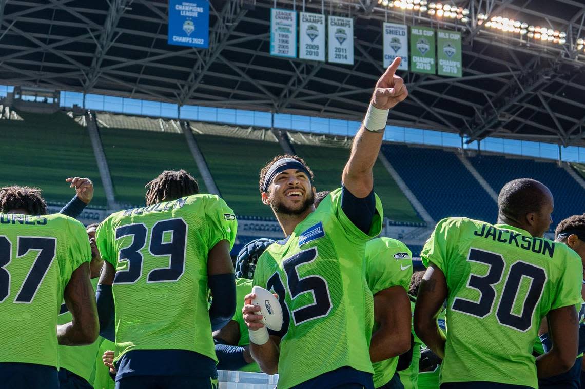 Seattle Seahawks free safety Joey Blount points to the crowd before throwing a signed football for one of them in Lumen Field on Saturday Aug. 6, 2022. At his left is rookie cornerback Tariq Woolen (39).