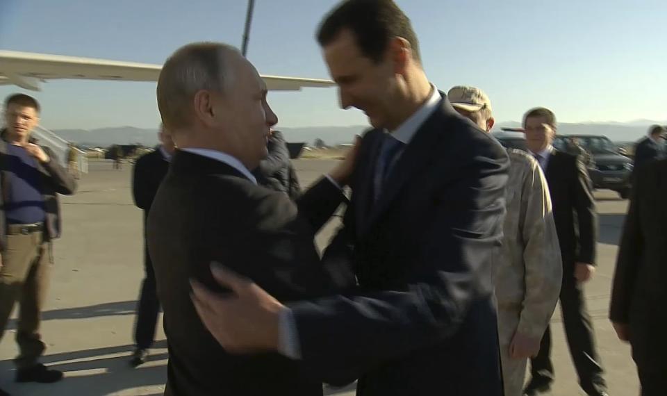 FILE - In this photo taken from video distributed by Russian Presidential Press Service, Syrian President Bashar Assad, right, greets Russian President Vladimir Putin upon his arrival to the Hemeimeem air base in Syria on Dec. 11, 2017. The Russian military intervention in Syria allowed Syrian President Bashar Assad's government to reclaim control over most of the country and helped expand Moscow's clout in the Middle East. (Russian Presidential Press Service via AP, File)