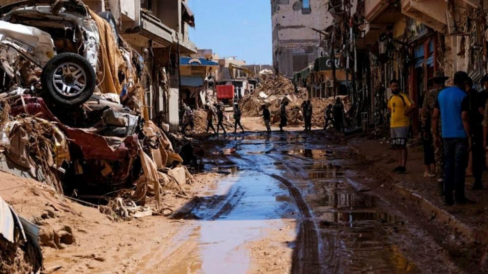 Varias personas caminan junto a casas destruidas por las fuertes lluvias e inundaciones en Derna, Libia, el 13 de septiembre de 2023. (Crédito: Esam Omran Al-Fetori/Reuters)