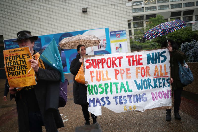 Gente protesta contra la falta de equipo de protección personal (PPE) afuera del Hospital St Thomas, luego del brote del COVID-19, la enfermedad causada por el coronavirus, en Londres