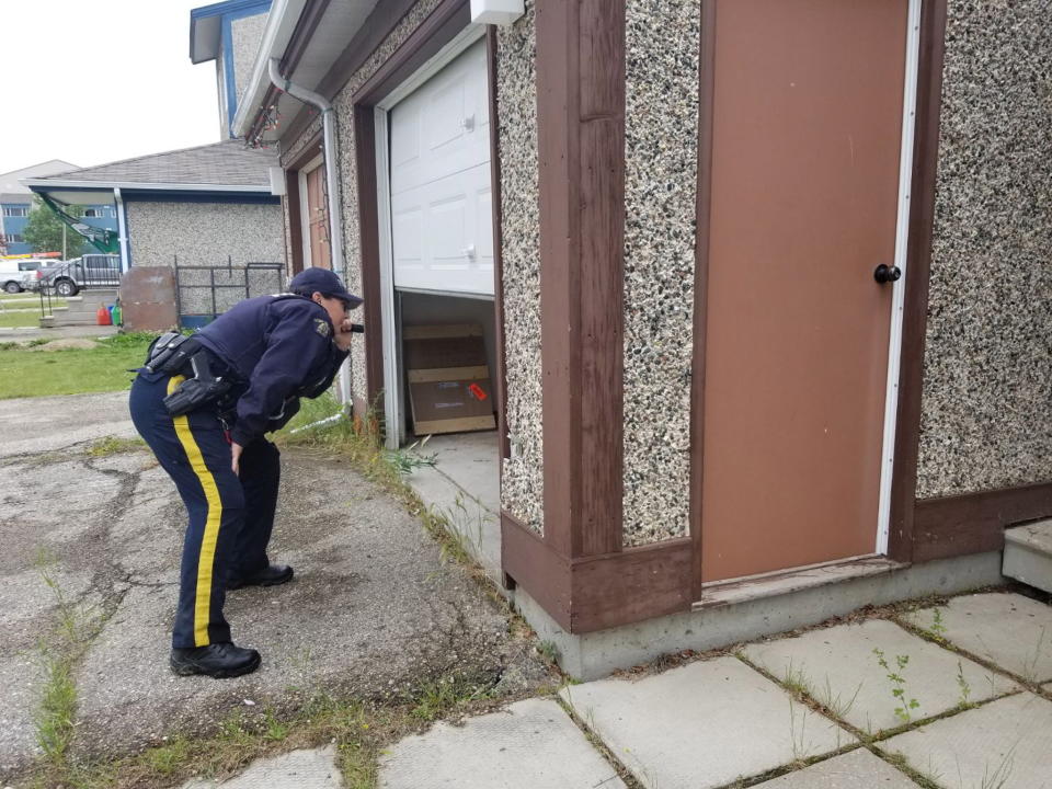 A police officer looks to the garage of a home in Gillam.  