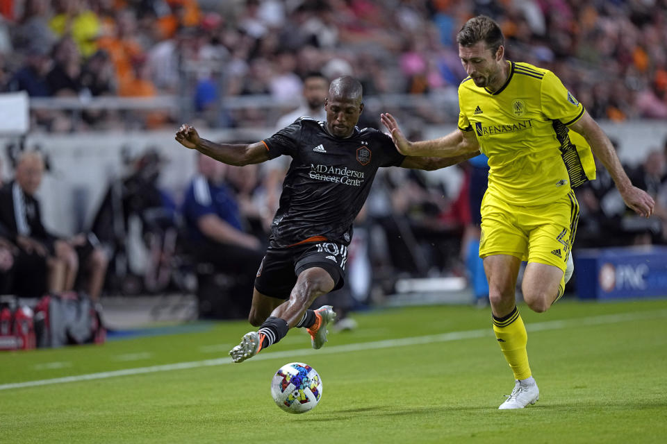 Houston Dynamo's Fafà Picault (10) drives toward the goal as Nashville SC's Dave Romney (4) defends during the first half of a soccer match Saturday, May 14, 2022, in Houston. (AP Photo/David J. Phillip)